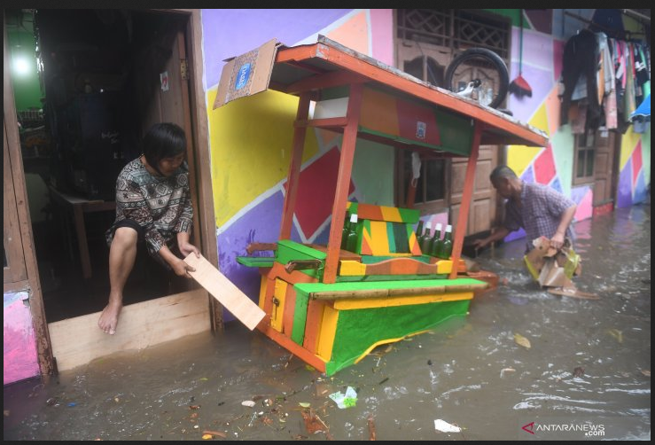 Warga membersihkan sampah yang terbawa air saat banjir merendam kawasan RW 5, Duren Tiga, Pancoran, Jakarta, Kamis (18/2/2021). ANTARA FOTO/Akbar Nugroho Gumay/wsj.